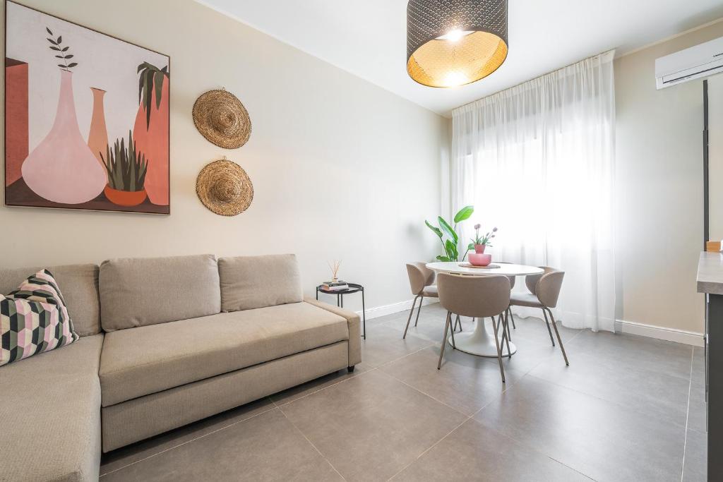 a living room with a couch and a table at Corner Apartment via Italia in Quartu SantʼElena
