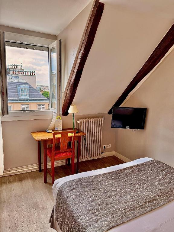 une chambre avec un lit, un bureau et une fenêtre dans l'établissement New Hôtel Gare Du Nord, à Paris