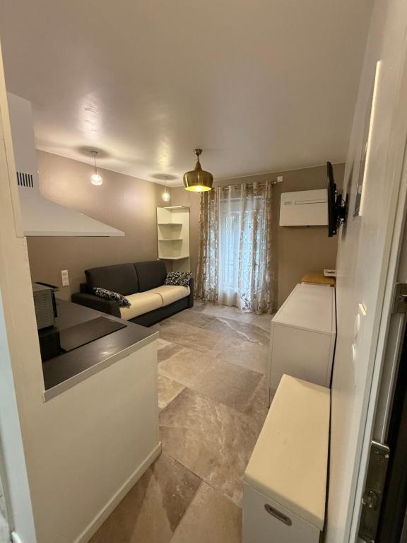 un petit salon avec un canapé et une cuisine dans l'établissement studio centre ville, à Narbonne