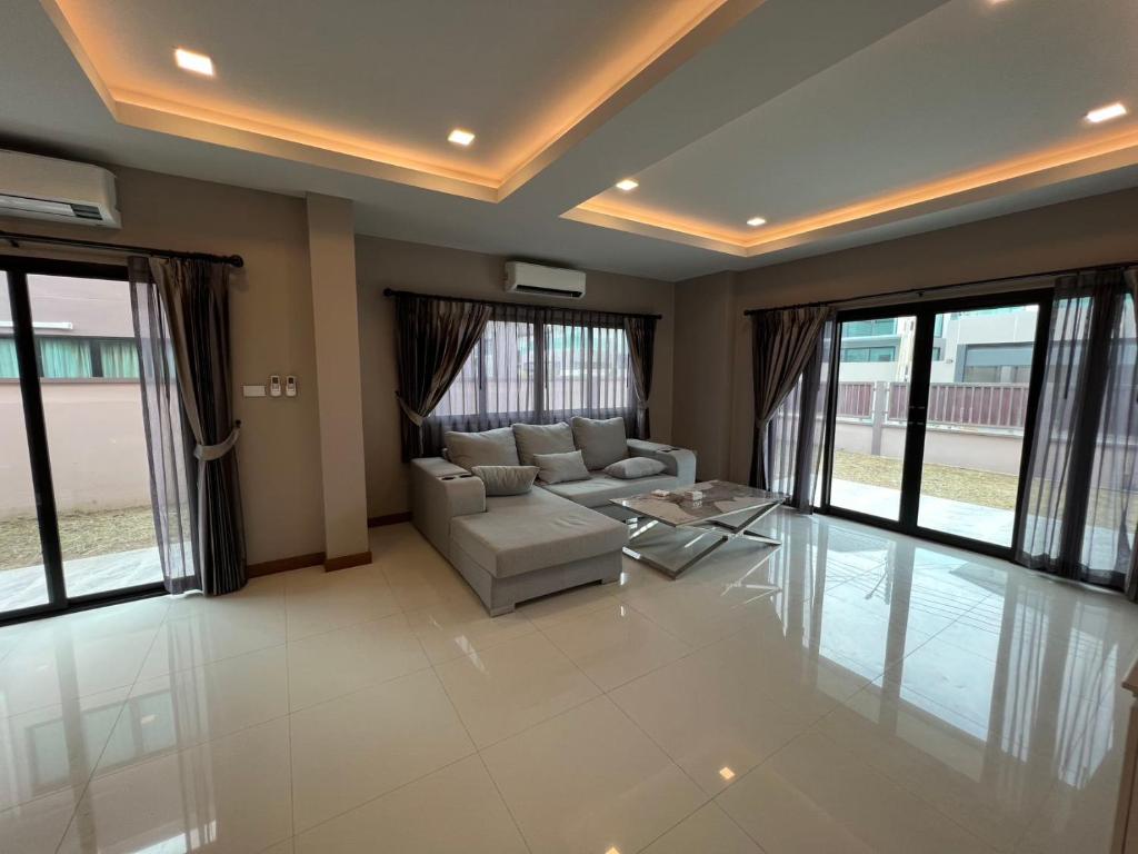 a living room with a couch and a table at The Lake Huay Yai Three-Bedroom Villa in Ban Huai Yai