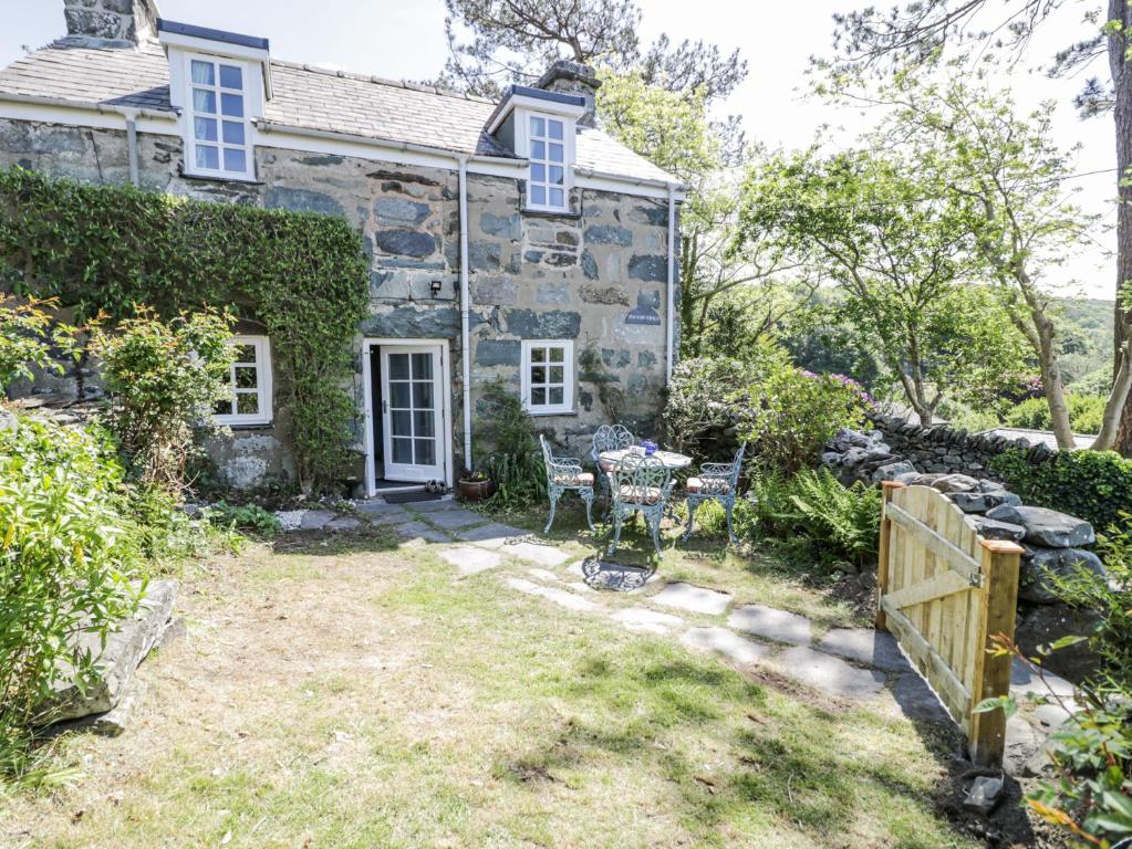 an old stone house with a garden in front of it at Pen Y Bryn Bach in Harlech