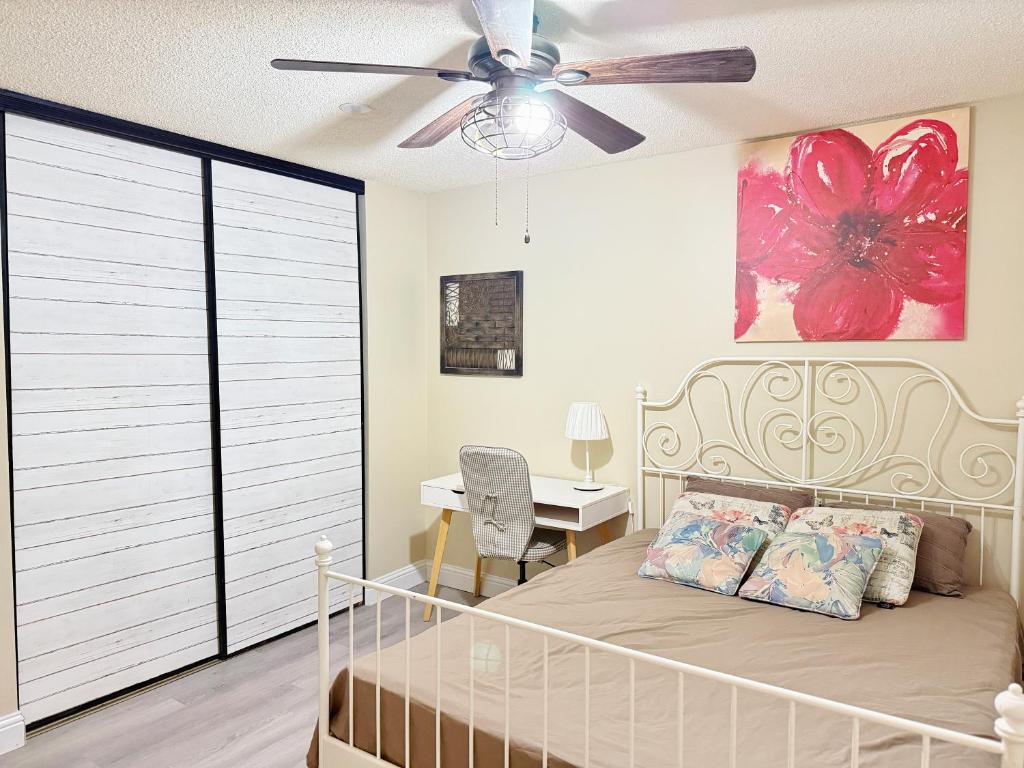 a bedroom with a bed with a ceiling fan and a desk at Gorgeous House&30 second Bus station Close C-Train& Free Parking in Calgary