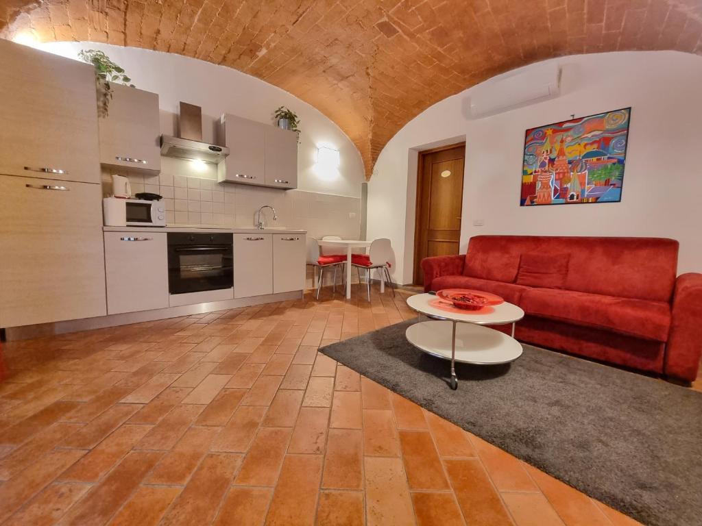 ein Wohnzimmer mit einem roten Sofa und einem Tisch in der Unterkunft Toscanella23 in Florenz