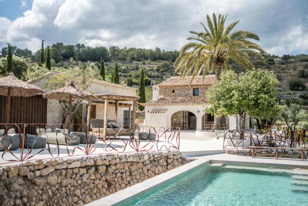 een villa met zwembad en een resort bij Finca de los Secretos in Benissa