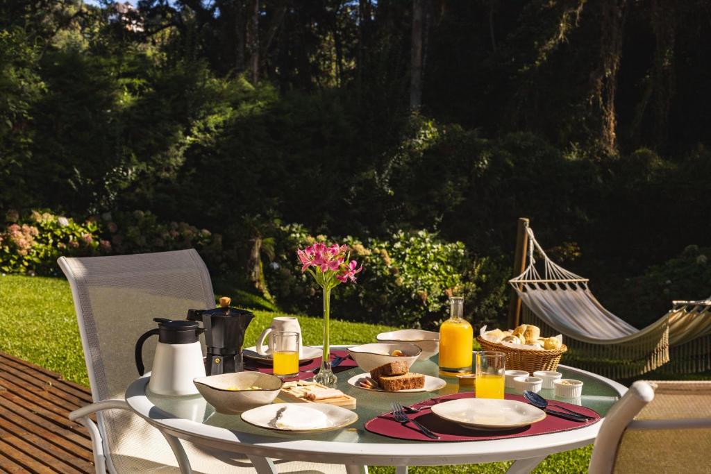 a table with food and drinks on it at I am Boutique Hotel Campos do Jordão by Unna in Campos do Jordão