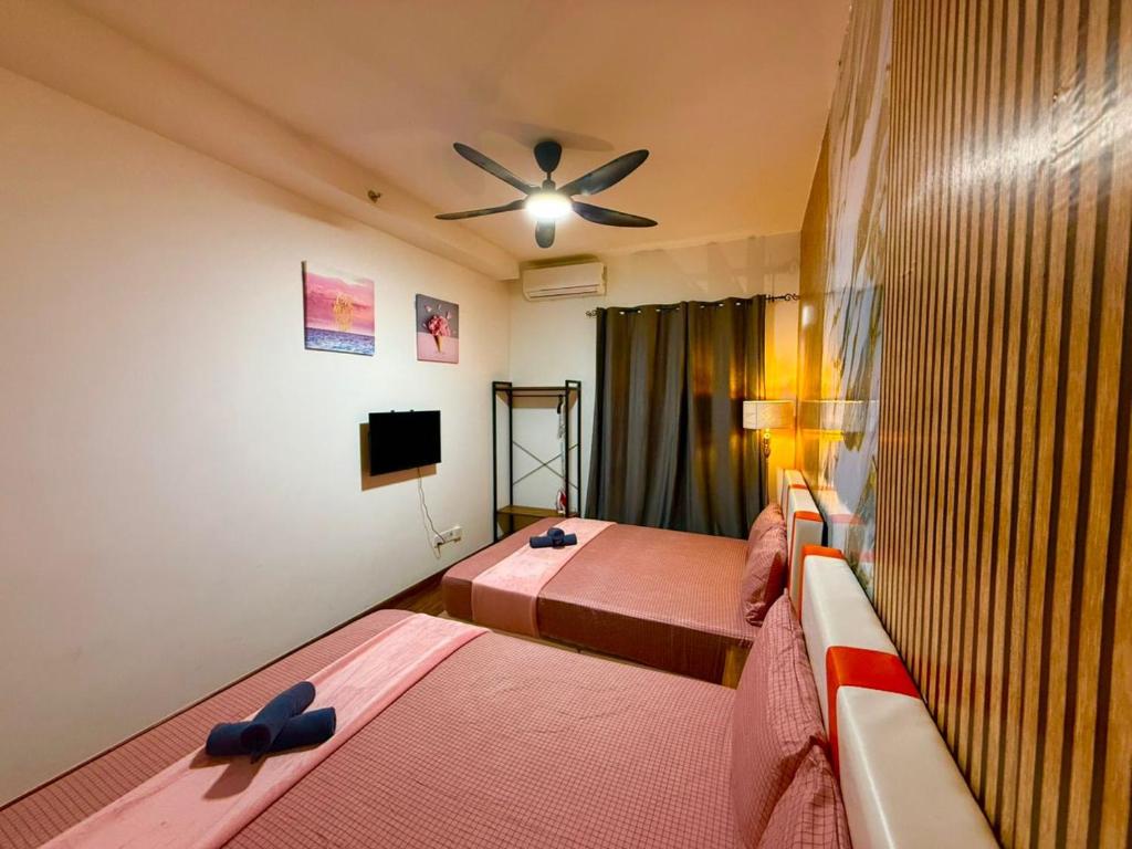 a bedroom with two beds and a ceiling fan at K avenue by TZ homestay in Donggongon
