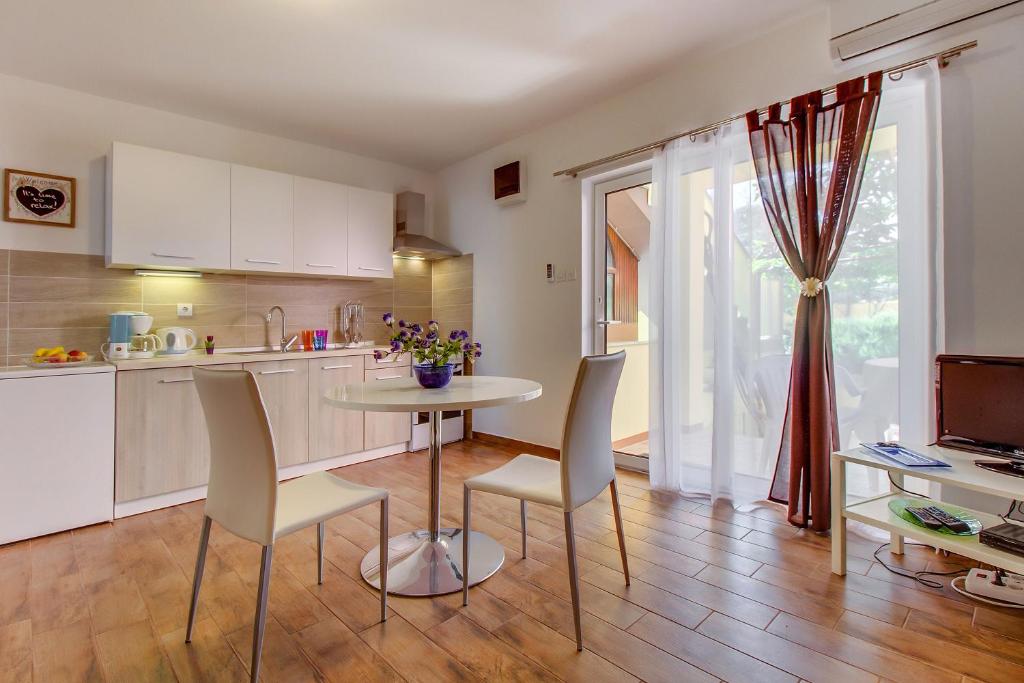 uma cozinha com mesa e cadeiras num quarto em Apartments Petra em Mali Lošinj