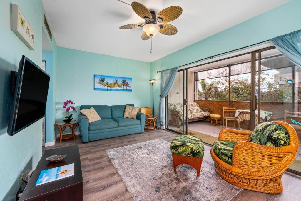 a living room with a couch and a tv at Big Island Kona Plaza 220 by Coldwell Banker Island Vacations in Kailua-Kona