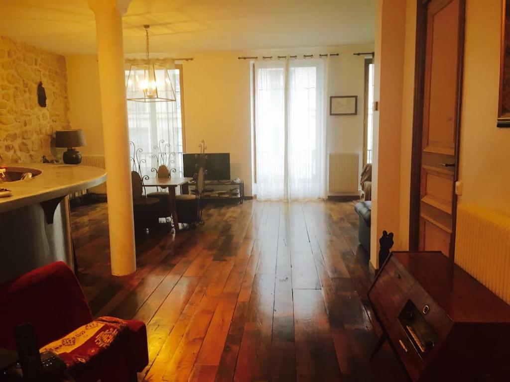 Il comprend un salon doté de parquet et une chambre avec une table. dans l'établissement superbe 2 pièces au centre de paris, à Paris