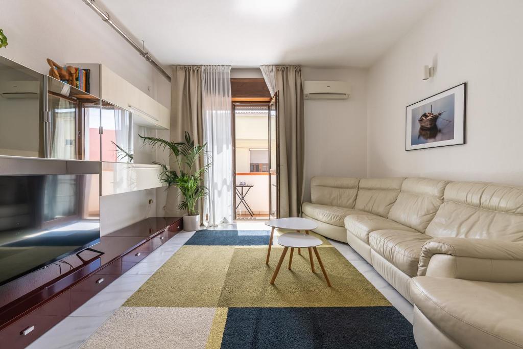 un salon avec un canapé et une télévision dans l'établissement Scarlatti Family Nest, à Quartu SantʼElena