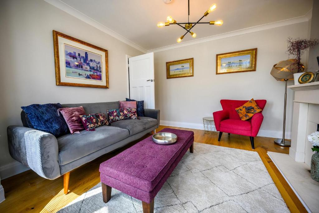 sala de estar con sofá y silla roja en Warrington - Large Beautiful Home - Great Location In South West By StayStaycations, en Bristol
