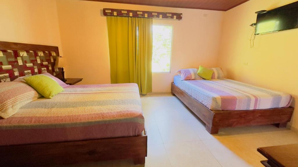 a bedroom with two beds and a window at La Serrania B&B in Boquete