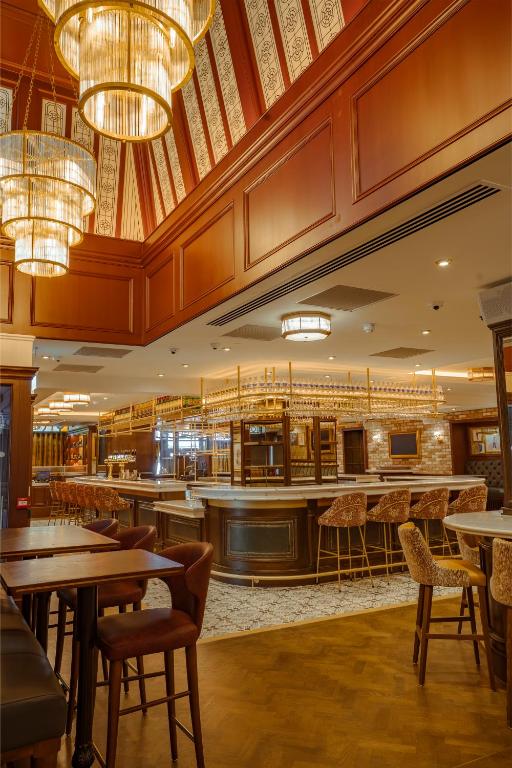 a restaurant with tables and chairs and chandeliers at The Mercantile Hotel in Dublin