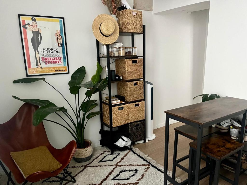 une salle à manger avec une table et une étagère avec des paniers dans l'établissement Appartement quartier Montorgueil, à Paris