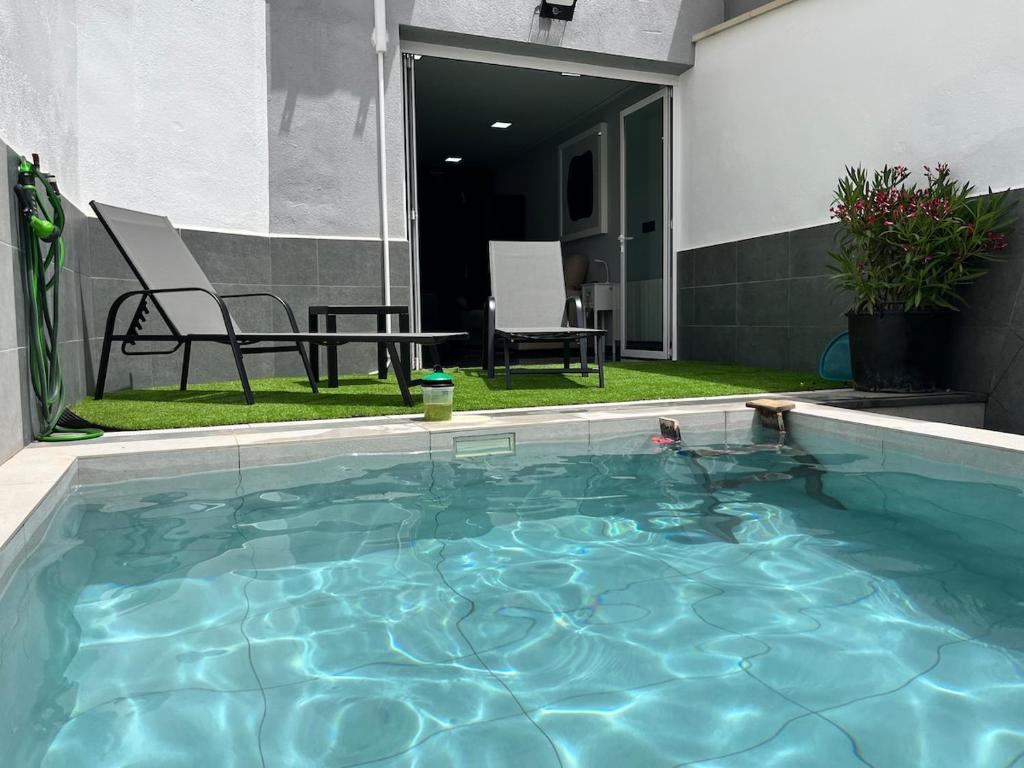 a swimming pool in the middle of a yard with two chairs at IN LOVE in Mahora