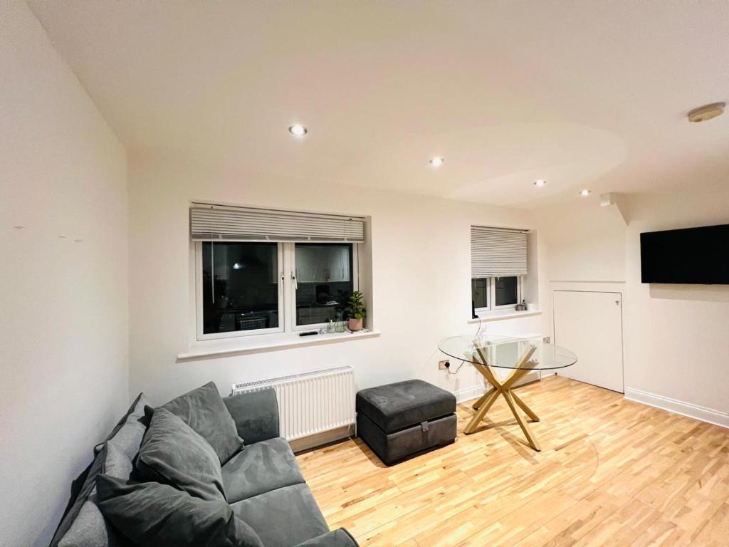 a living room with a couch and a table at Spacious flat on the High St in Beckenham