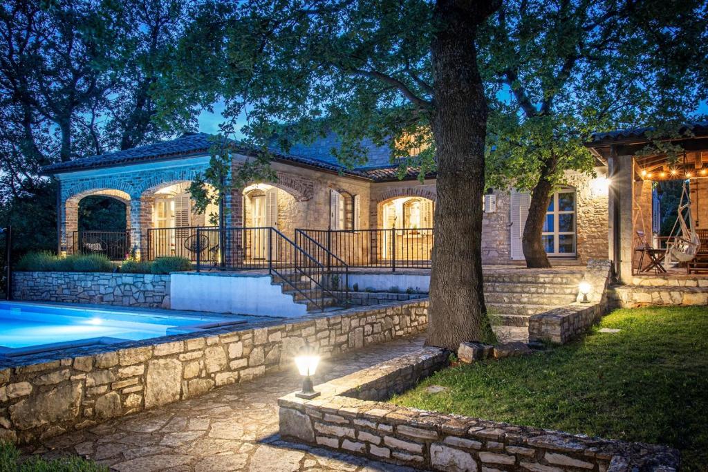 a house with a swimming pool and a tree at Villa Rovere Orbani in Orbani