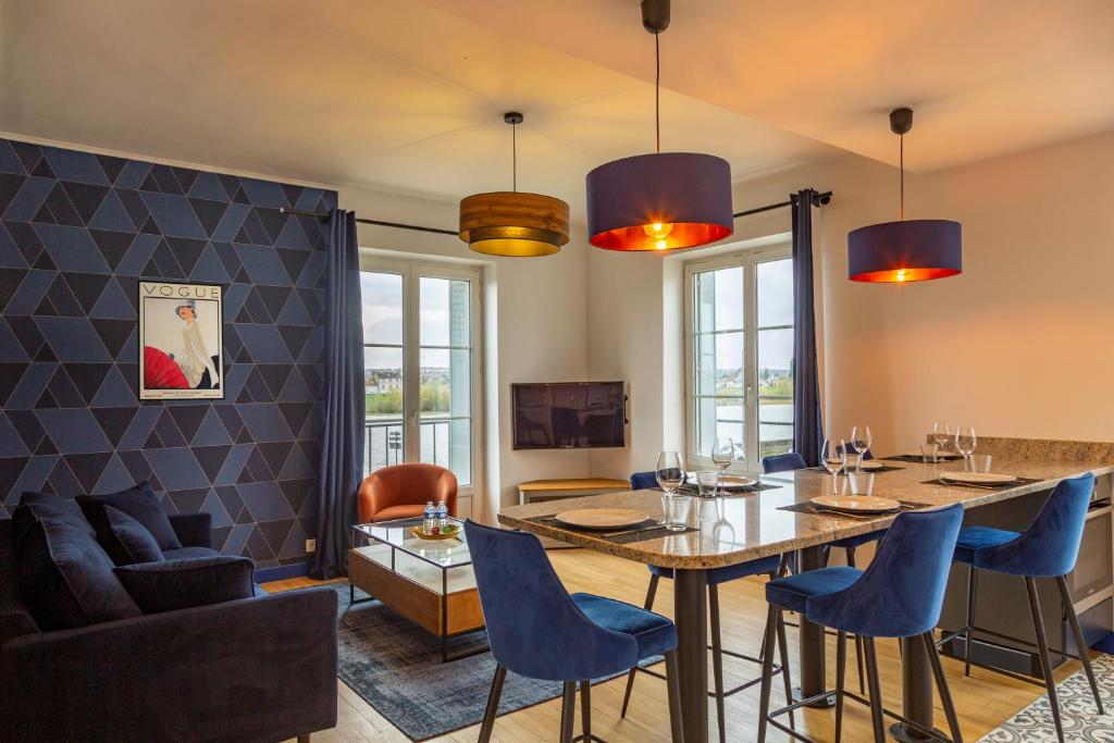 une salle à manger avec une table et des chaises bleues dans l'établissement - L'instant Loire - Vue sur la Loire, à Blois
