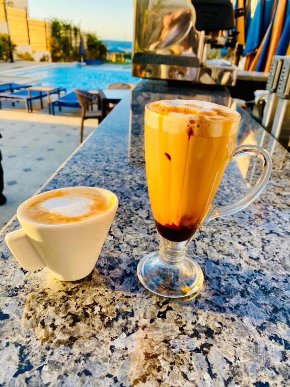 a drink and a cup of coffee sitting on a table at Tiba Rose hurghada in Hurghada