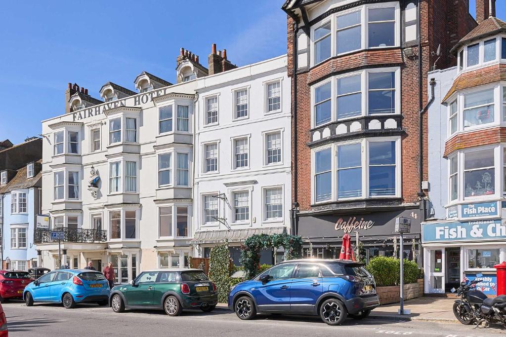 a row of cars parked in front of a building at Host & Stay - Albert House in Weymouth