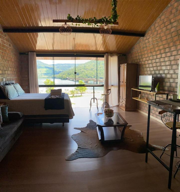 a bedroom with a bed and a large window at Pousada Refúgio das Águas Quarto 2 in Chapecó