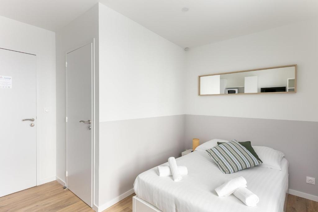 - une chambre blanche avec un canapé blanc et un miroir dans l'établissement Brocéliande, à Brest