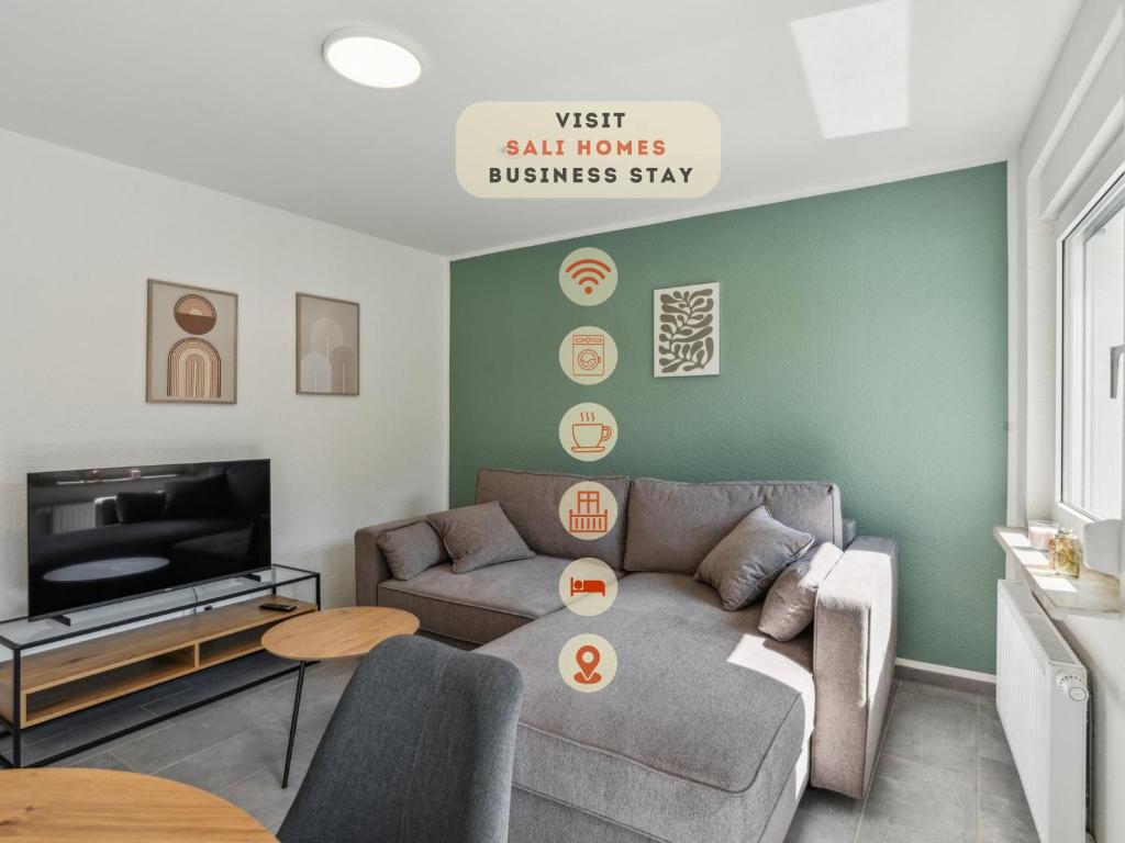 エメリッヒにあるSali Homes-Komfort Apartment Haus in Emmerich am Rheinのソファとテレビのあるリビングルーム