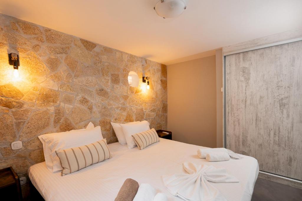 Un dormitorio con una cama y una pared de piedra. en Villa Hyacinthe by A&D Properties, en Porto Rafti