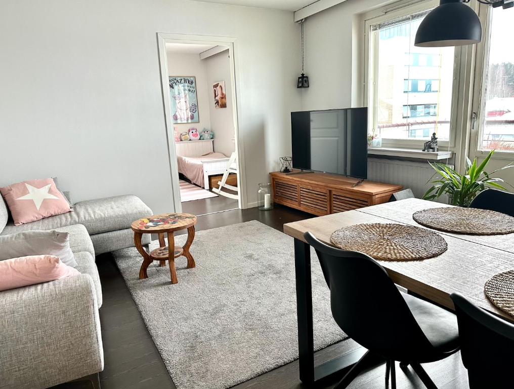 un soggiorno con un divano e un tavolo di Valoisa 44,5 m2 kaksio Lahden keskustassa a Lahti