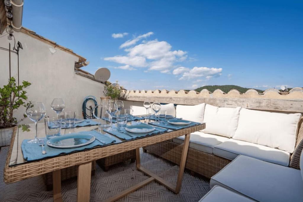 - une table avec des verres à vin et un canapé sur la terrasse dans l'établissement Peaceful stay near Saint-Tropez, à La Garde-Freinet