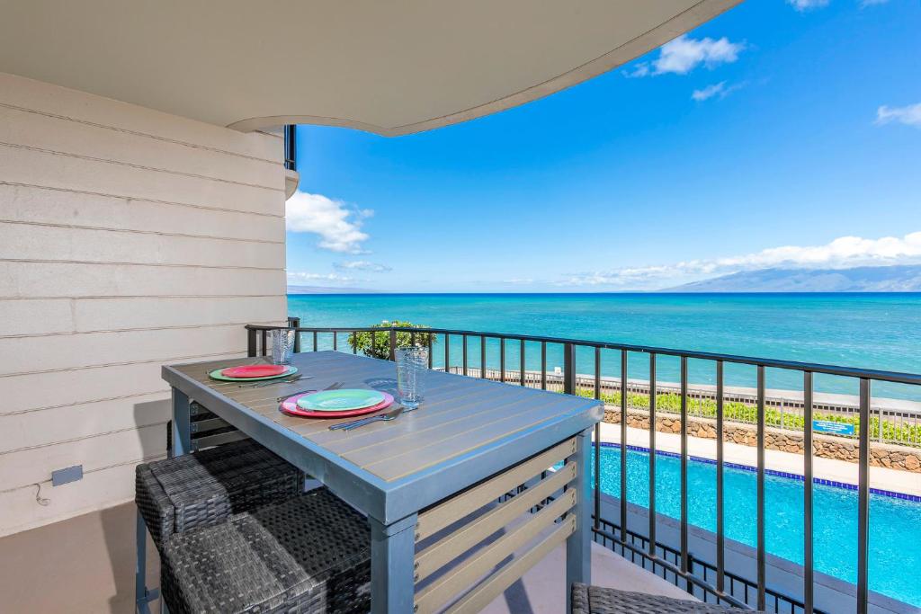 a table on the balcony with a view of the ocean at Kahana Reef 205 by Coldwell Banker Island Vacations in Kahana