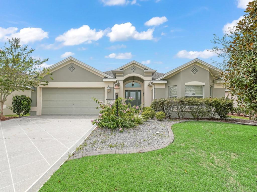 a large house with a driveway at 2500 Z3A VILLAGE OF TAMARIND GROVE by REMAX Premier in The Villages