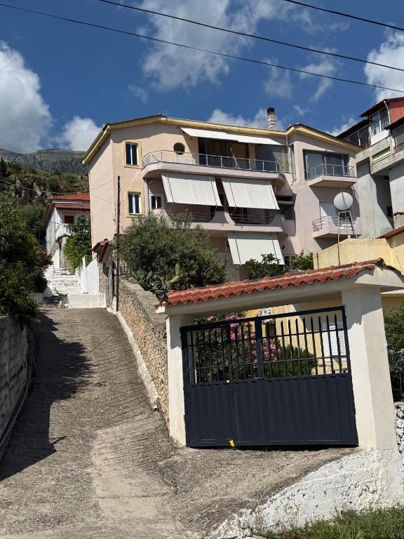 a building with a gate in front of a house at Emilios house in Dhërmi