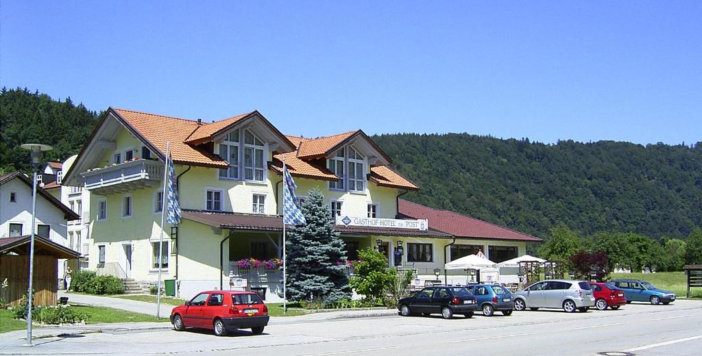 een groep auto's geparkeerd voor een gebouw bij Gasthof Hotel zur Post in Erlau