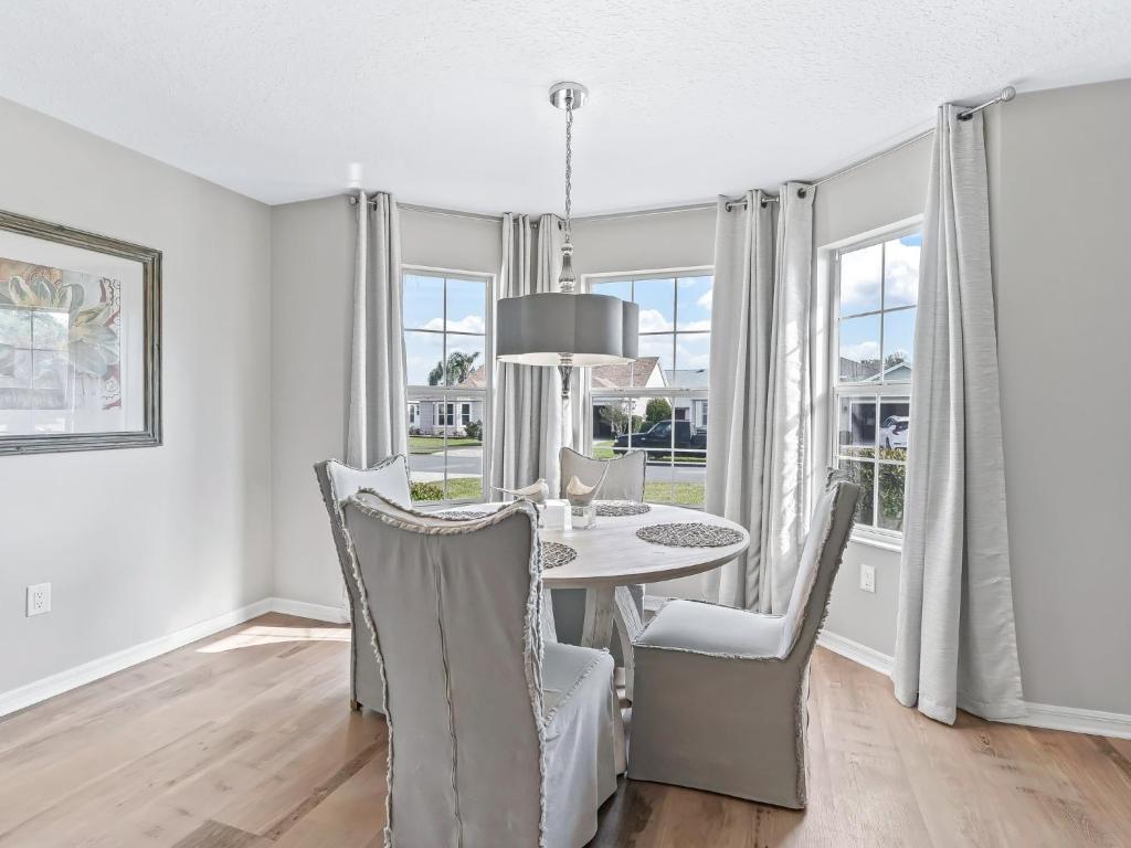 a dining room with a table and chairs and windows at 3270 Z2A VILLAGE OF GLENBROOK by REMAX Premier in The Villages