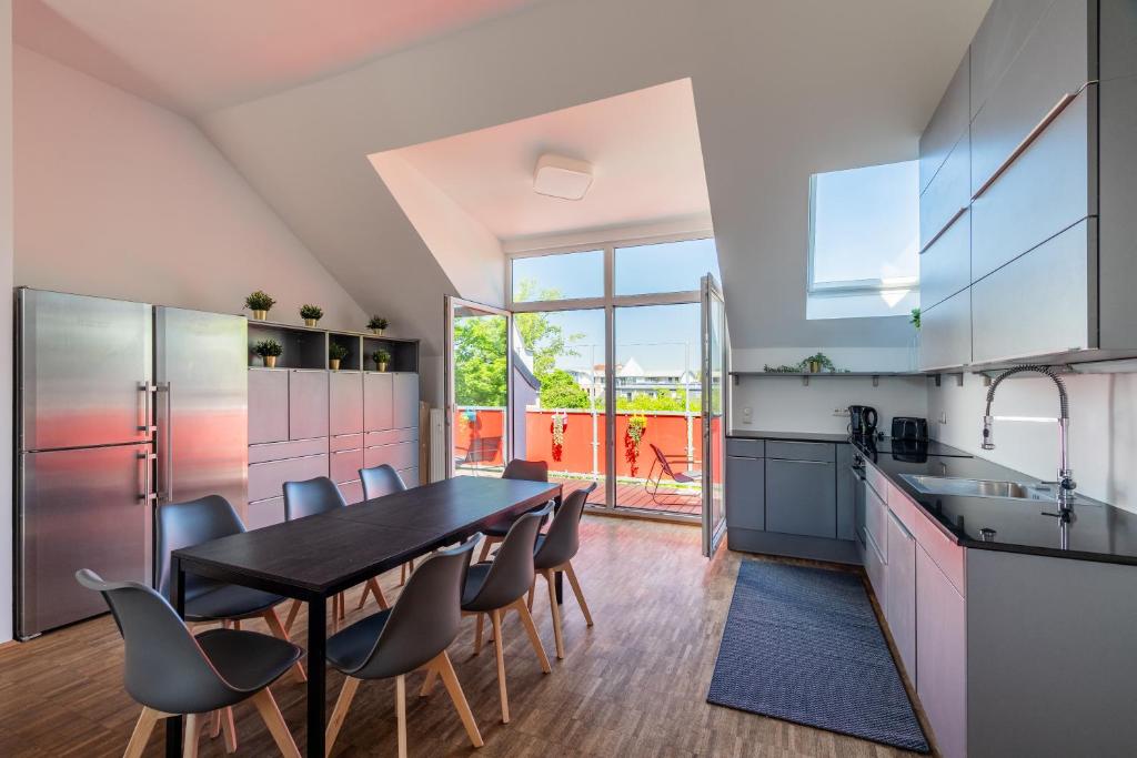 a kitchen with a dining room table and chairs at Sky Loft Leipzig - moderne Dachwohnung mit Terrasse und Blick aufs Rathaus in Leipzig