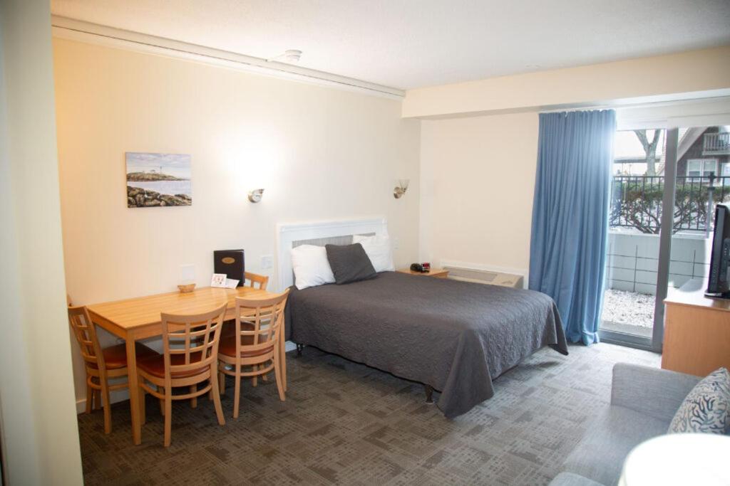 una camera da letto con un letto, un tavolo, un tavolo e delle sedie di Courtyard Resort a Hyannis