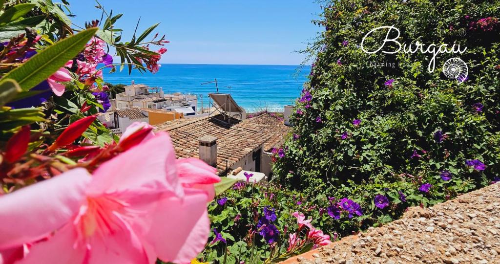 ブルガウにあるBurgau Charming House Loftの花の咲く庭園から海を望む