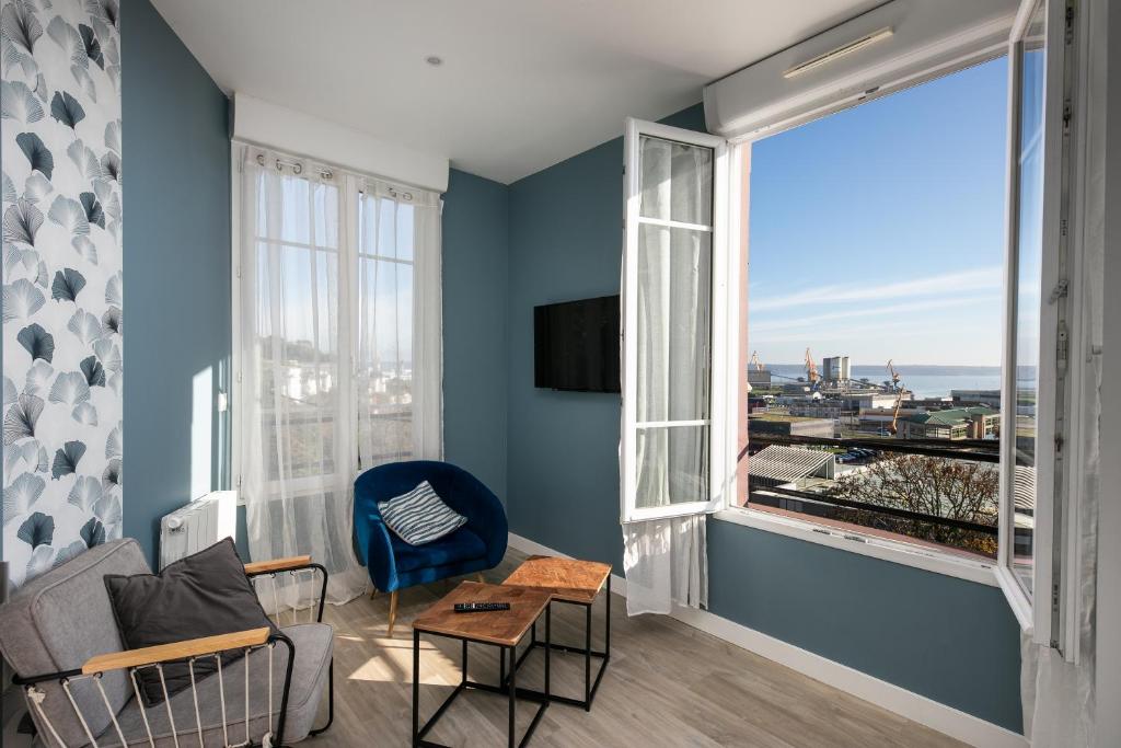 d'un salon avec des murs bleus et une grande fenêtre. dans l'établissement Le Dellec, à Brest