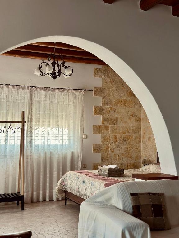 a bedroom with a bed and an arched window at Home Sweet Home Milos in Triovasálos