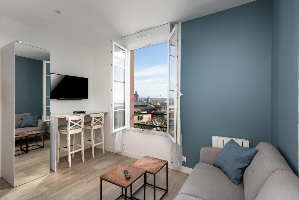 un salon avec un canapé et une grande fenêtre dans l'établissement Sainte Anne du Porzic, à Brest