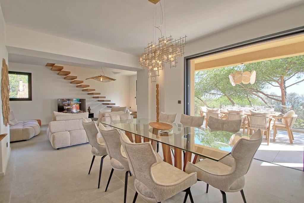 une salle à manger avec une table et des chaises en verre dans l'établissement Villa vue mer, piscine, plage à pieds, à Hyères