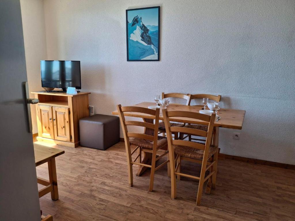 une salle à manger avec une table, des chaises et une télévision dans l'établissement Saint François Longchamp - T3 33m², proche pistes, 4 pers - FR-1-807-133, à Saint-François-Longchamp