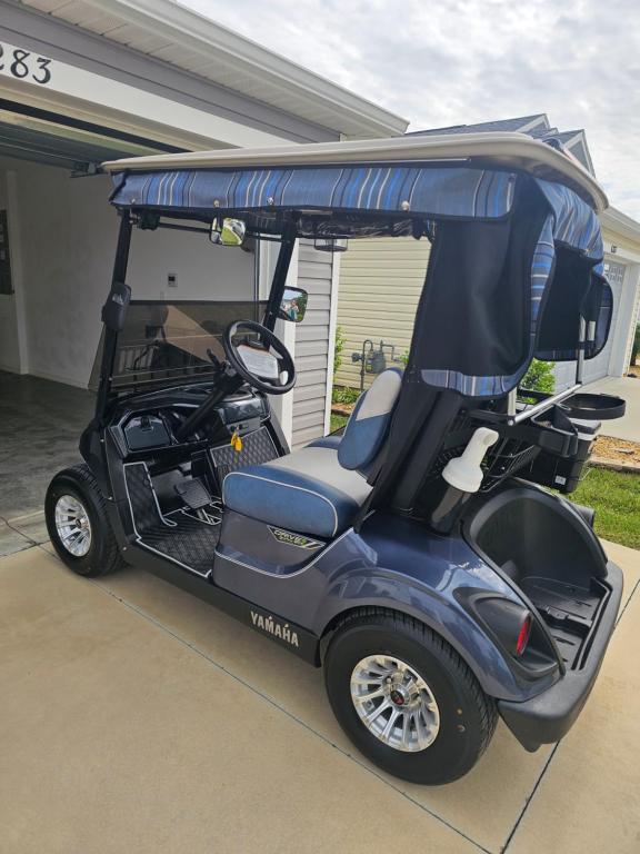 un carro de golf estacionado fuera de una casa en 6283 Z5 VILLAGE OF CITRUS GROVE by REMAX Premier, en The Villages