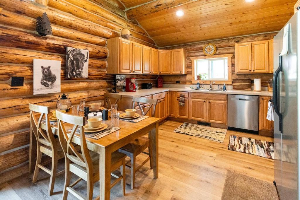a kitchen with wooden cabinets and a table with chairs at Firepit & Outdoor Dining|Sleeps 10|Dogs Welcome in Seeley Lake