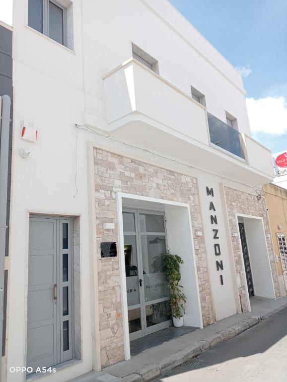 a white building with a sign on the side of it at B&B Manzoni 2 in Neviano