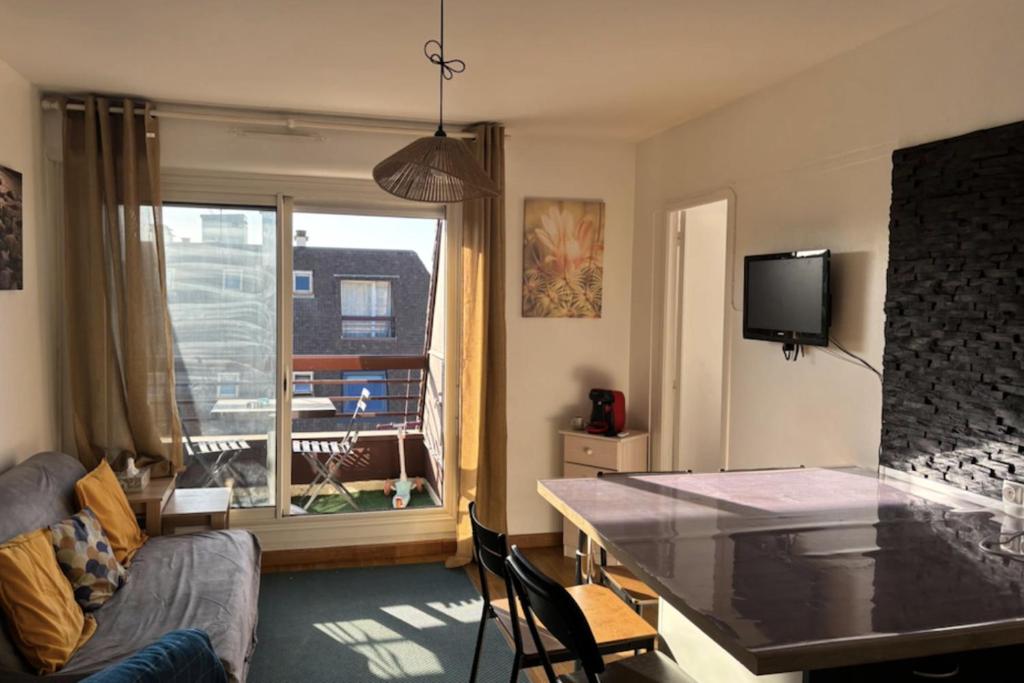 un salon avec une table et un canapé dans l'établissement Superb flat with sea views, à Houlgate