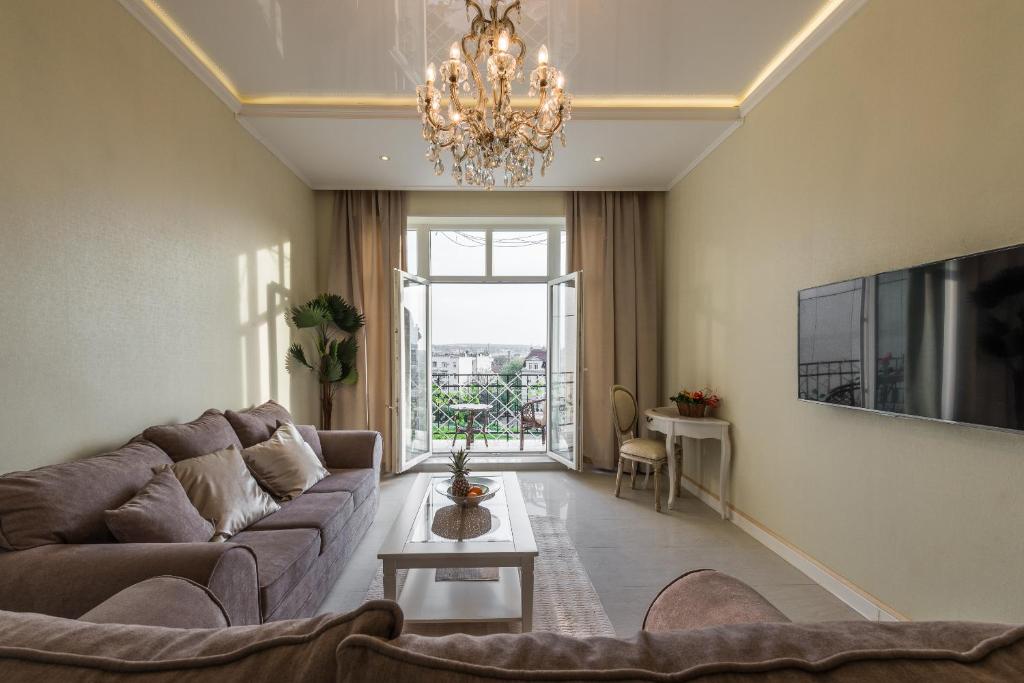 sala de estar con sofá y lámpara de araña en Max Luxury Apartments en Belgrado
