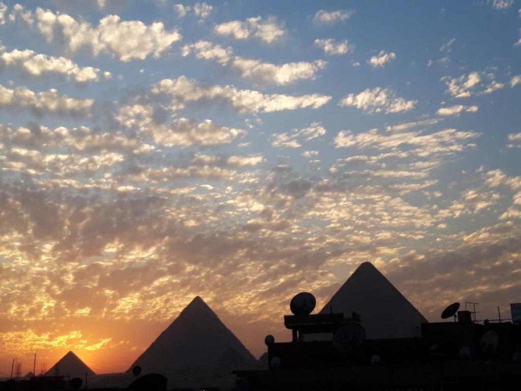 a view of pyramids with a cloudy sky in the background at مفتاح الحياه in Banī Ghālib