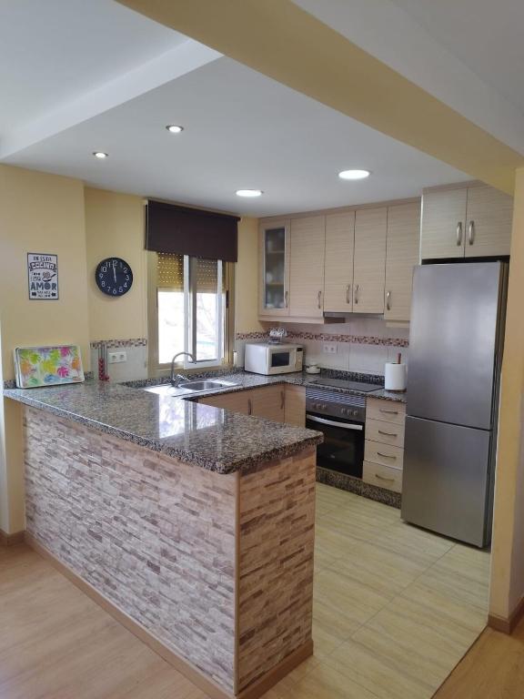 a kitchen with a large counter with a refrigerator at sol y arena in Santa Pola